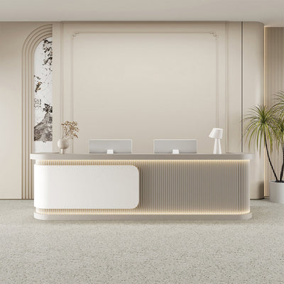 Salon reception desk front view with white curved fluted panels and metallic accents